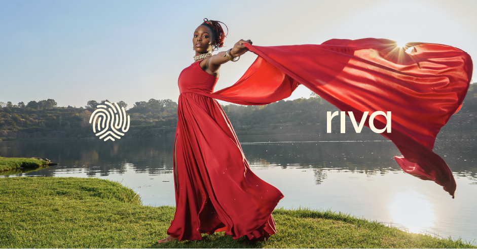 Black woman in long red dress with a dramatic looking scarf blowing from her dress, standing by a river. The word Riva and its fingerprint logo is beside her